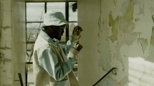 a man in white and blue jacket painting on wall