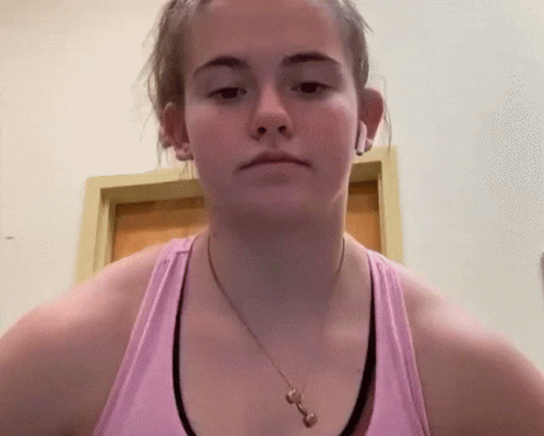 a woman in a pink tank top with a necklace