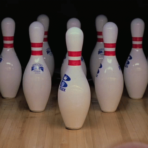 several white bowling balls sitting next to each other on top of a blue floor
