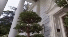 the house is painted white with pillars and tree decorations