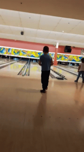 children bowling on a bowling alley during a dark night