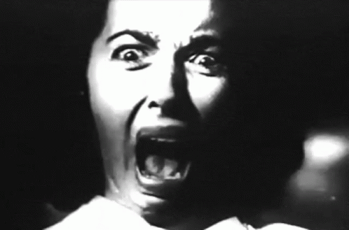 a woman with her mouth open is in the dark