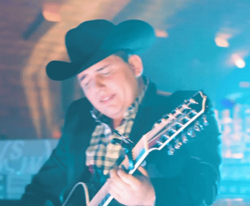 a man with a cowboy hat holding a guitar