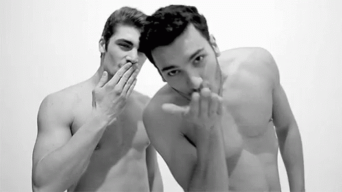 a male model and another man is holding his hands to their face