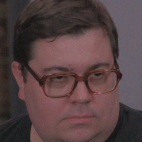 an image of man with glasses that is slightly frowning