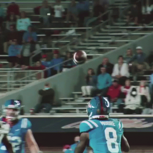two football players are throwing the ball in front of a crowd