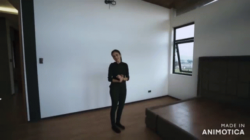 a person is standing in a room with dark furniture