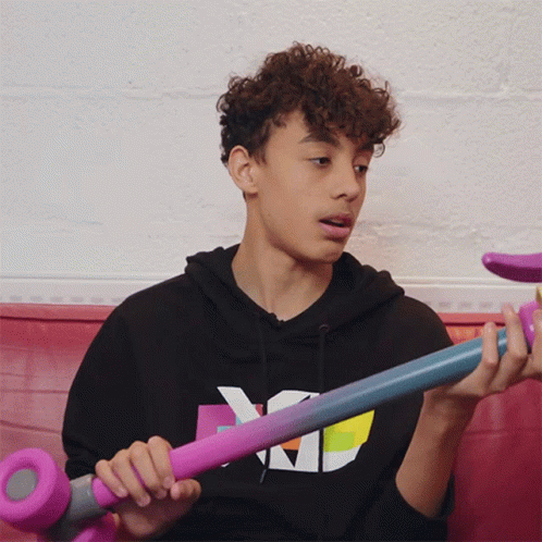 the boy is holding two different colored skateboards
