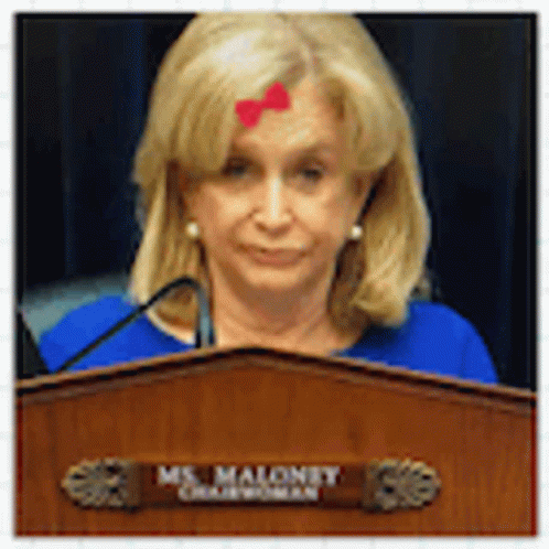 a woman at a podium with a blue cross on her forehead