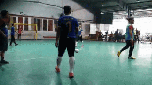 several men are in a gym playing soccer