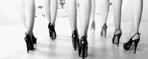 a bunch of black high heeled shoes lined up