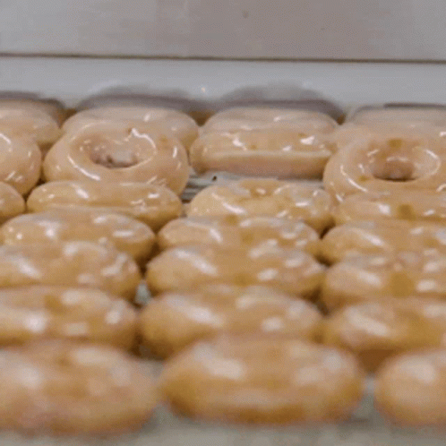 rows of glazed doughnuts sitting in a container