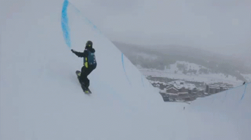 snowboarder on top of a snowy mountain and doing tricks