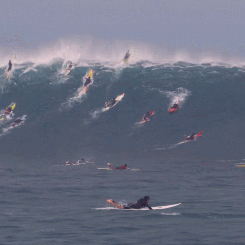 some people surfing a large wave in the ocean