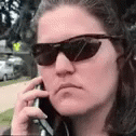 a woman is on her cell phone with sunglasses on