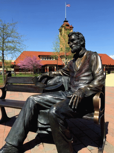 a statue of aham lincoln sitting on a bench