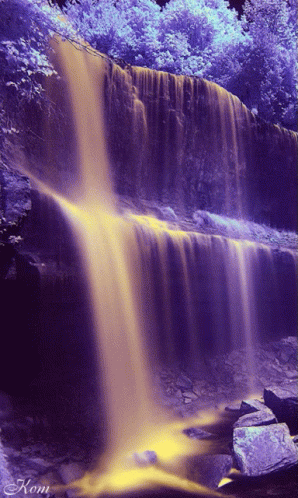 a large waterfall filled with water and colorful trees