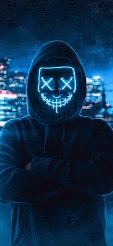 person wearing scary mask with city lights in background