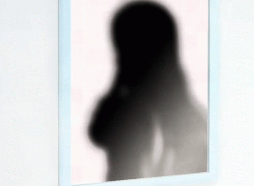 a woman's back and long arms in the shadow of a mirror