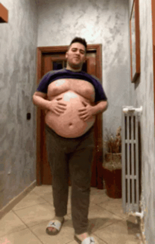 a man is carrying a big belly in a hallway