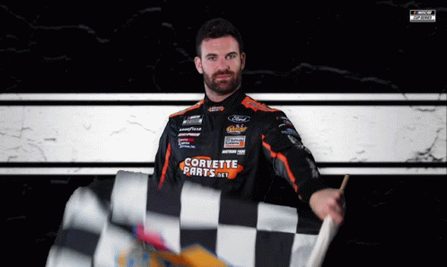 a nascar professional car driver holds up his checkered flag
