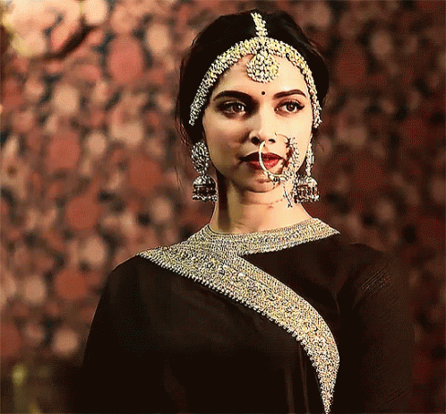 an indian woman in a black outfit standing with jewelry