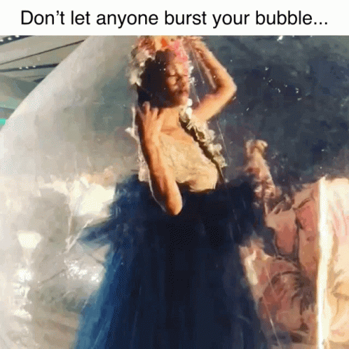 a woman wearing a white gown floating in a bubble