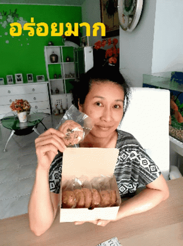 a woman holding a box with some food