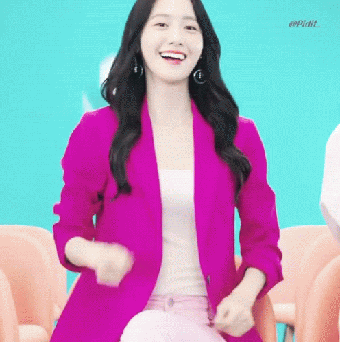 a woman in pink sitting on a blue chair smiling