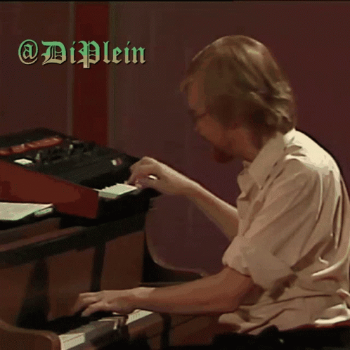 a man sitting at a piano playing a musical instrument