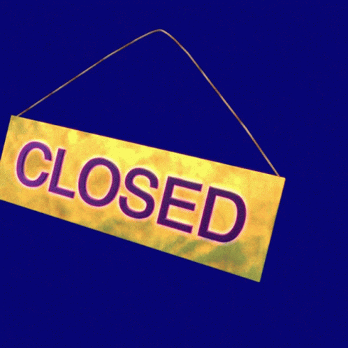 a closed sign hanging from a red and black wall