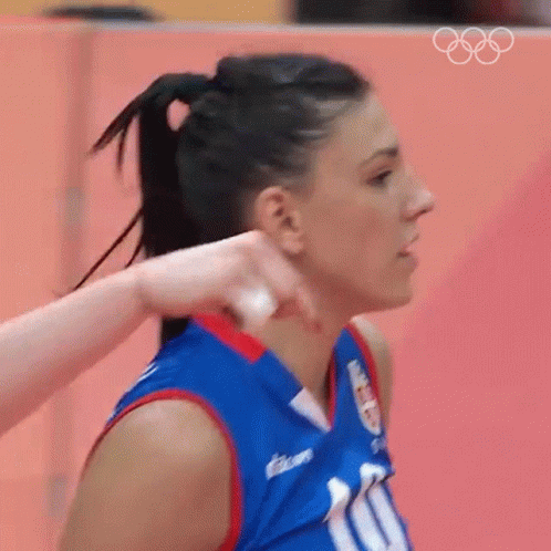 a women with a ponytail swinging a volleyball racket