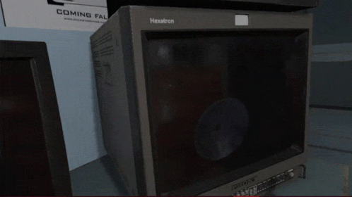 a black microwave and two black televisions are sitting on the shelf