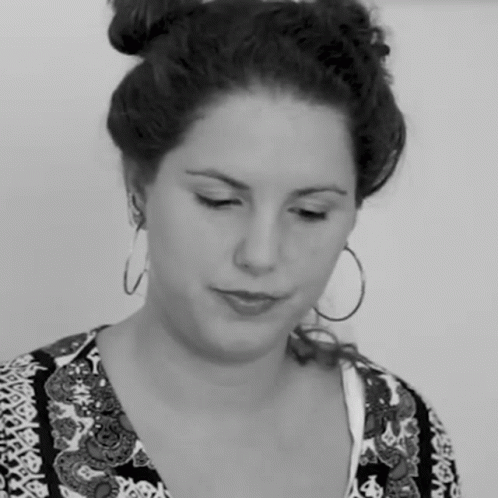 a woman with large round hoop earrings looking down