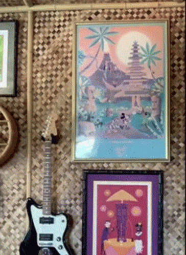 a bunch of framed pictures and an electric guitar
