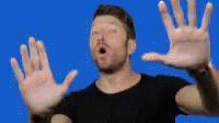 man making weird face with hands as an orange background