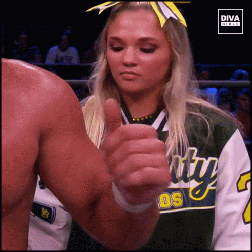 two female wrestlers are giving thumbs up
