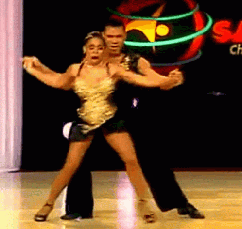 a young man and a woman performing salsa