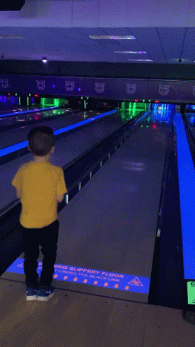 the young person is watching the bowling lanes