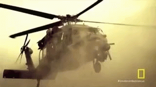 a helicopter in the air with its landing gear down