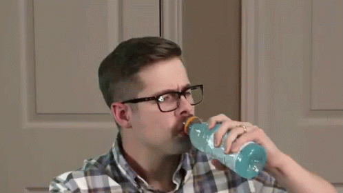 a man drinking out of an empty bottle