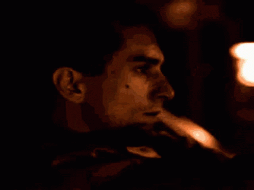 a man smokes in the dark, smoking a cigarette