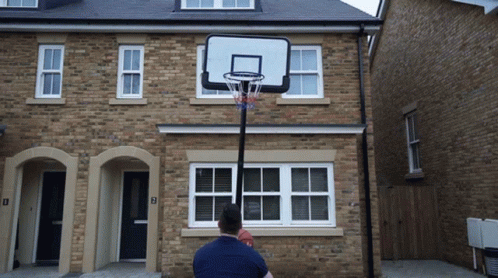 a basketball hoop is held up in front of a house