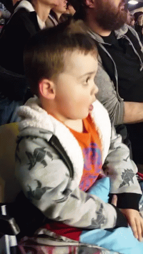 a boy sitting in the audience of an event