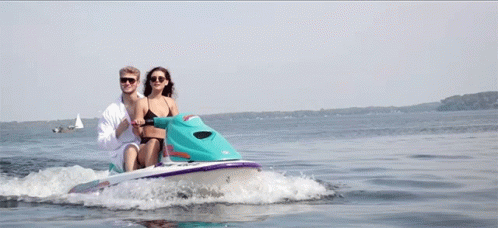 two blue people ride a small motor boat on the ocean