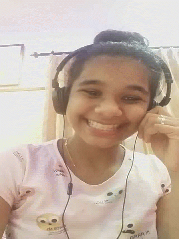 a girl with headphones on is smiling for the camera