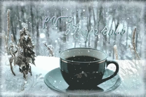 a black coffee cup in the snow with a horse behind it