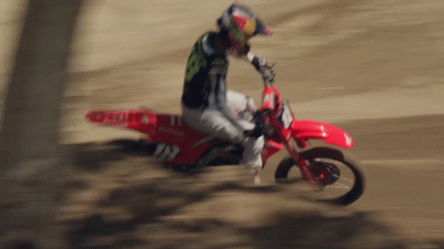 a man riding on the back of a blue dirt bike