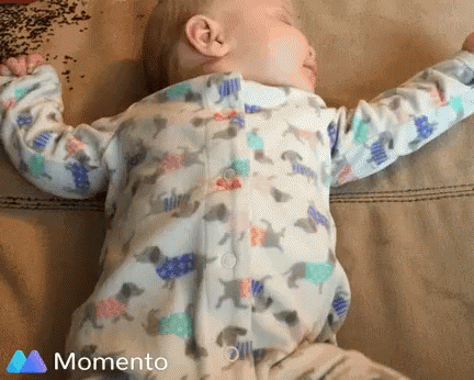 a baby wearing pajamas that are all over the pillow