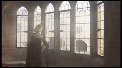 the scene is showing an old woman standing by two windows